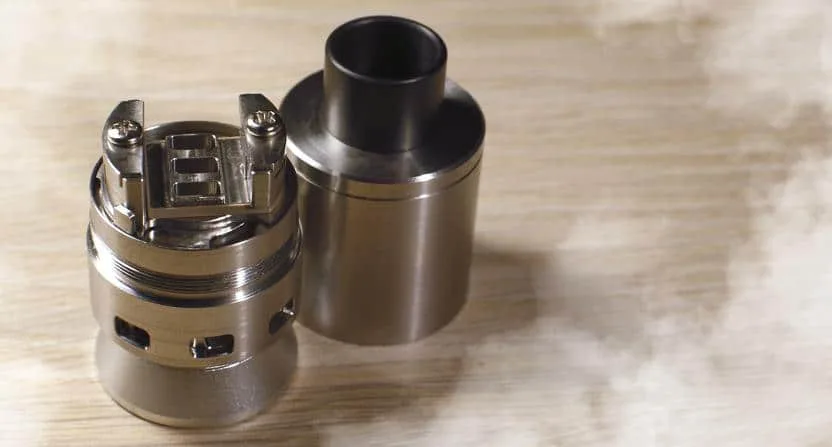 Vue éclatée d’un atomiseur reconstructible montrant le drip tip, la chambre, le plateau de montage, le coton, le réservoir et la base 510.