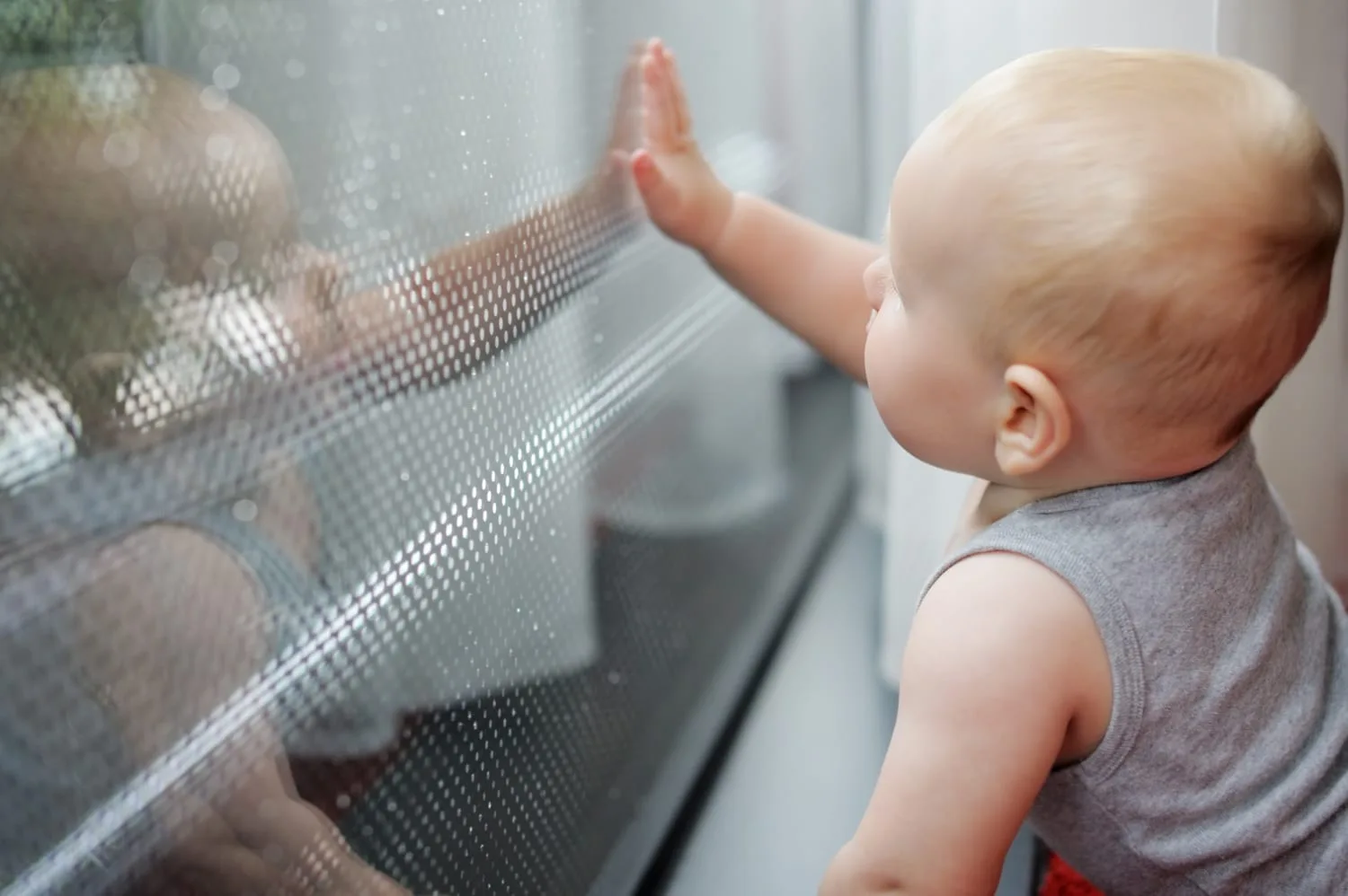 Bébé installé dans une poussette à l’ombre, protégée par une moustiquaire fine lors d’une sortie en extérieur.