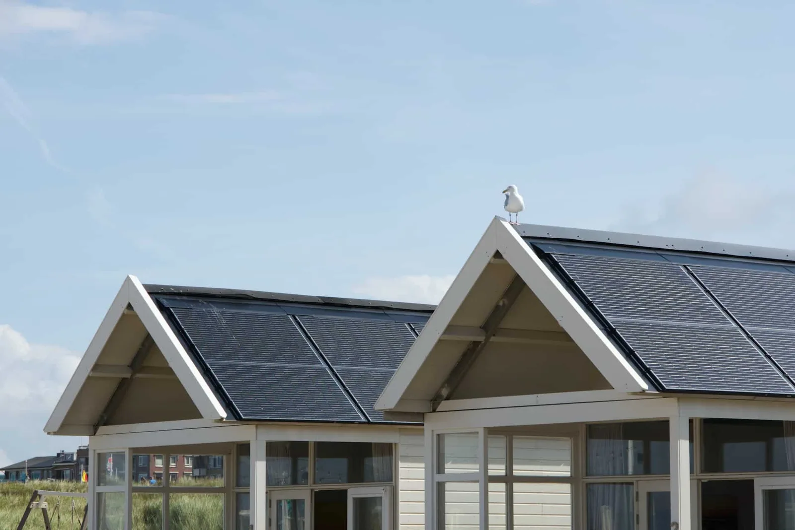 Installation de panneaux solaires sur un toit de maison avec batterie de stockage et ciel lumineux.