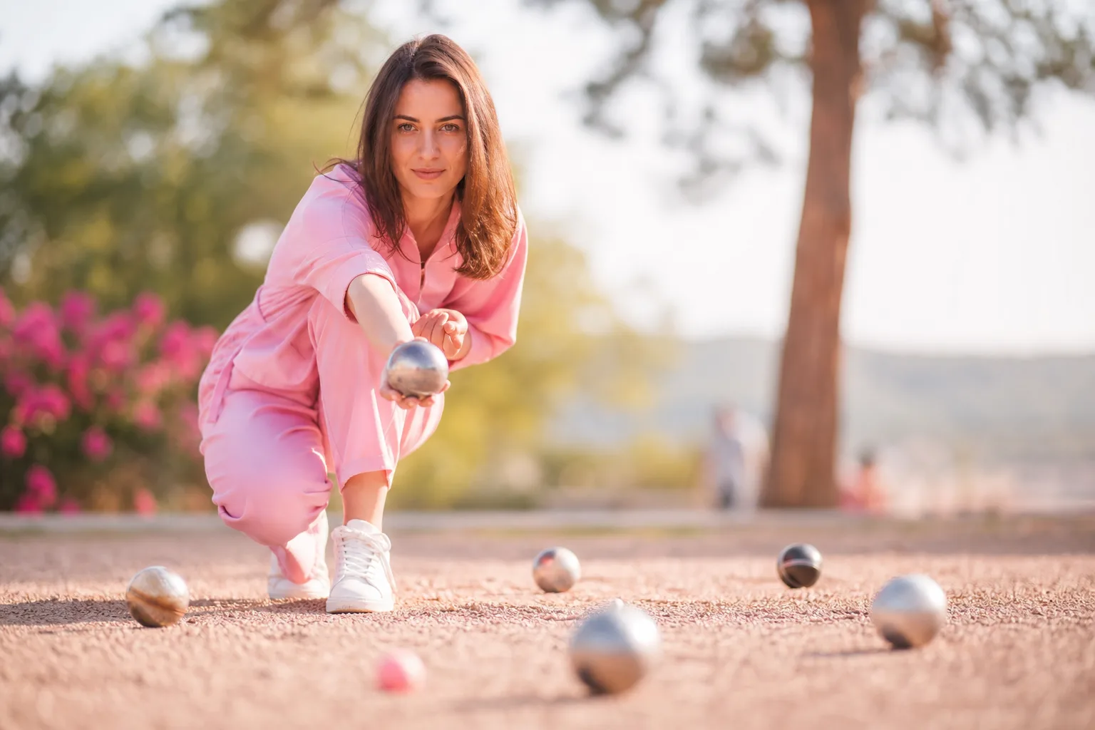 Jeu de trois boules de pétanque haut de gamme en acier posé sur un terrain de gravier, avec un cochonnet en bois.