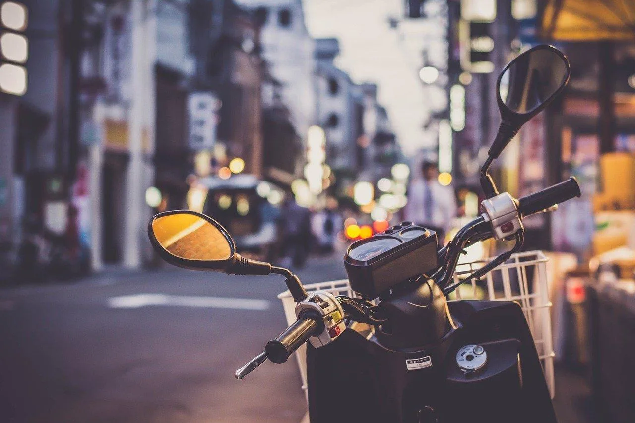 Motarde consultant son mémo d’assurance sur son téléphone à côté de sa moto stationnée.