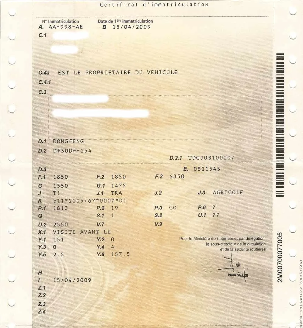 Ordinateur portable ouvert sur une démarche administrative de changement d’adresse de carte grise, avec clés de voiture et cartons de déménagement.
