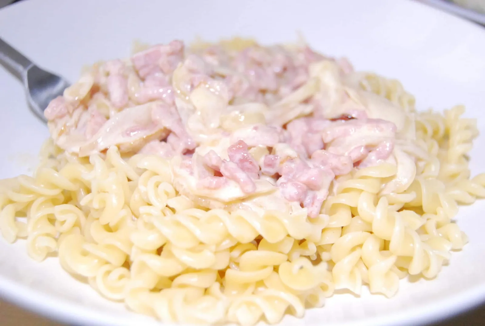 Assiette de spaghetti alla carbonara crémeux au guanciale, pecorino et poivre noir fraîchement moulu.