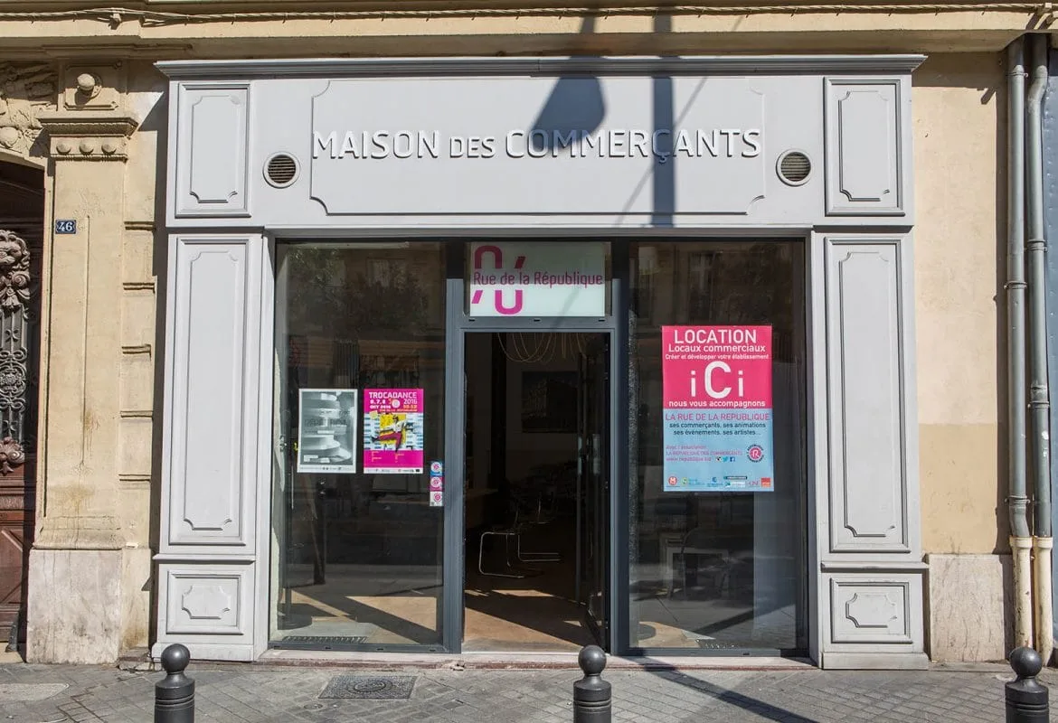 Entrepreneuse préparant l’ouverture de son commerce avec plans, ordinateur portable et échantillons produits sur un bureau.