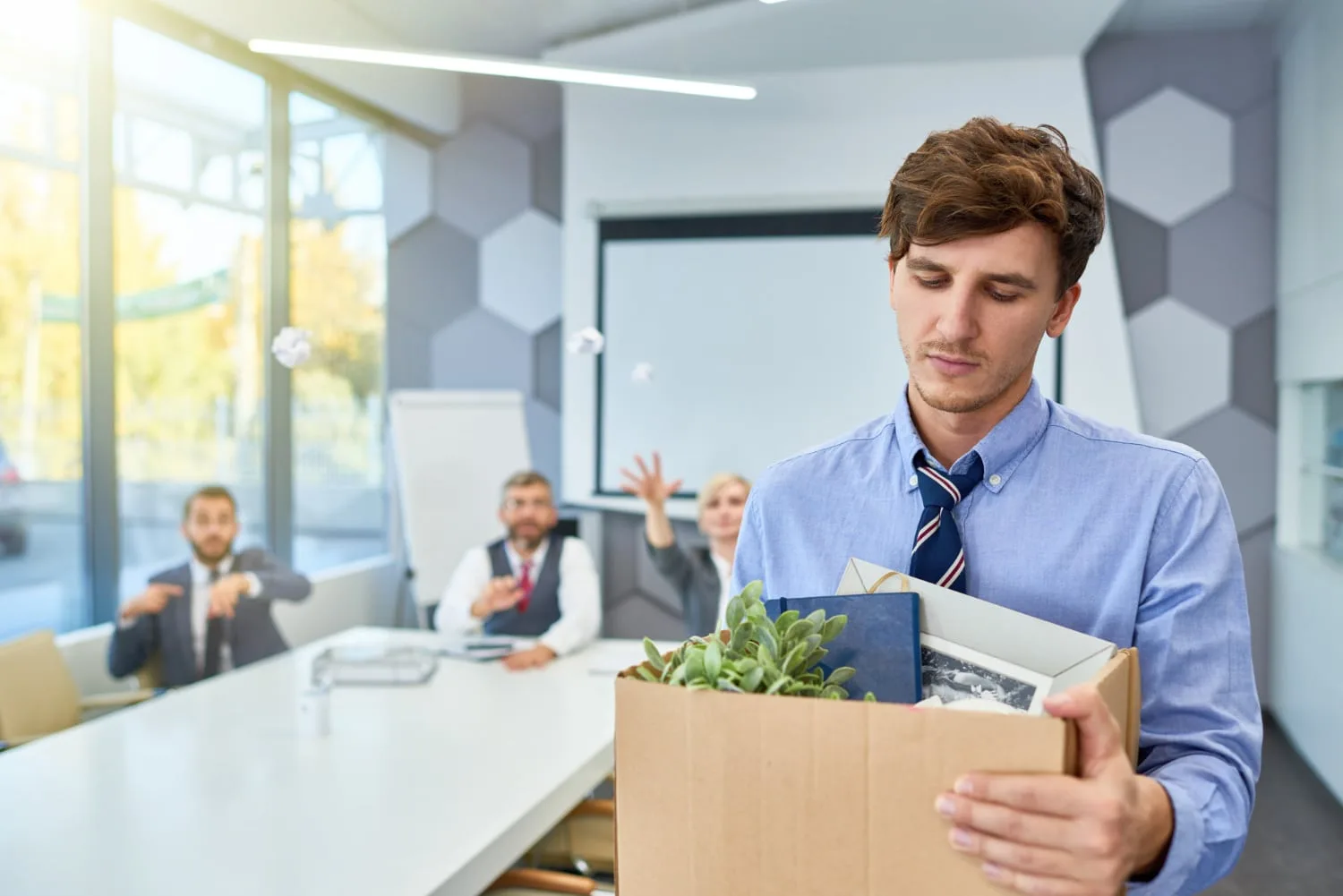 Entrepreneuse préparant des coffrets d’abonnement mensuel avec produits, cartons et étiquettes sur une table de travail.