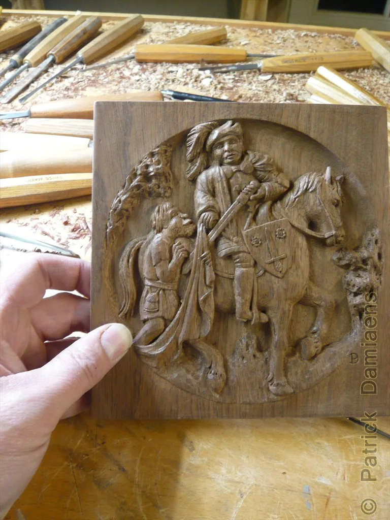 Mains sculptant délicatement une petite pièce de tilleul avec un couteau de sculpture, sur un établi en bois.