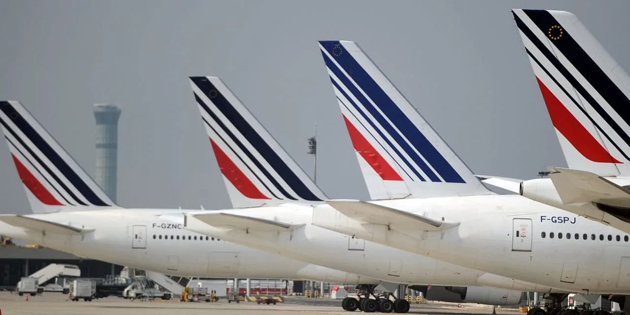 Voyageuse avec une valise à roulettes se dirigeant vers les départs de l’aéroport de Paris-Orly.