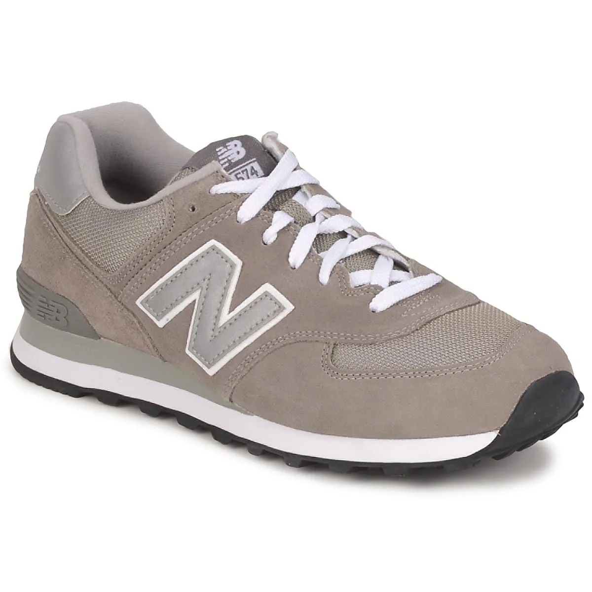 Femme essayant une paire de baskets New Balance beiges dans un intérieur lumineux.