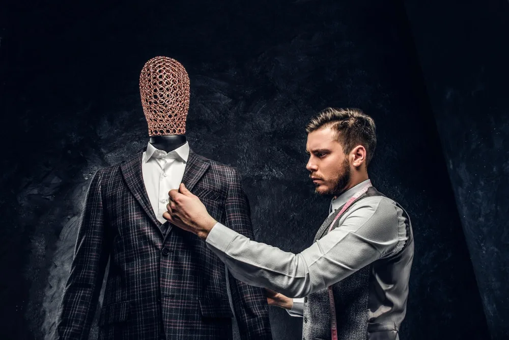 Femme portant un costume bleu marine sur mesure, ajusté à sa silhouette, dans un atelier de tailleur lumineux.