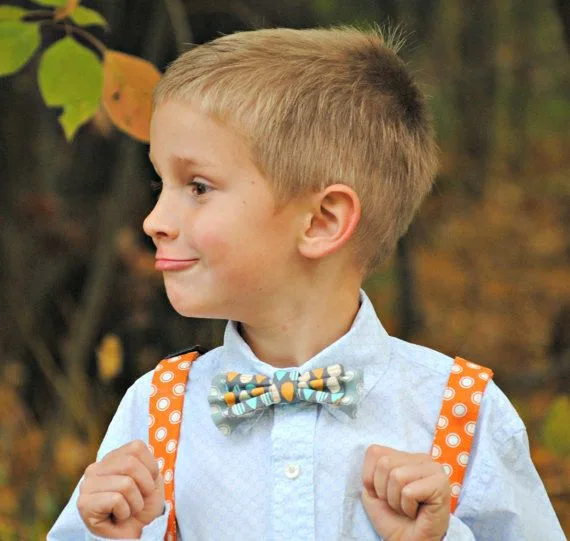 Enfant souriant portant des bretelles ajustables avec une tenue de cérémonie.