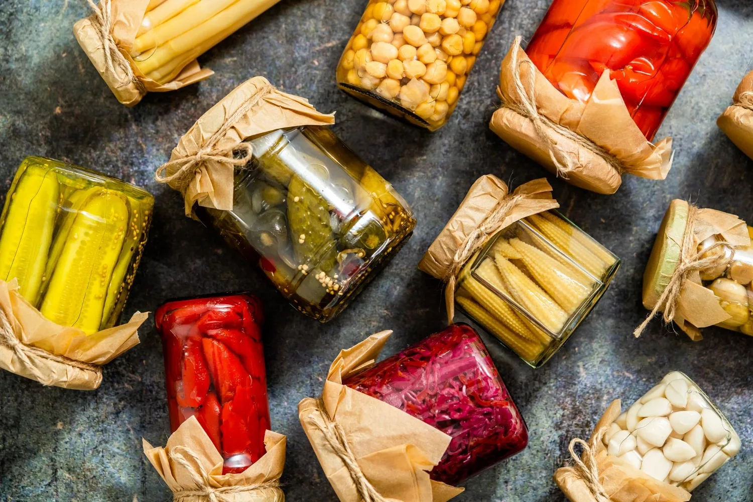 Bocaux de légumes lactofermentés, yaourt nature et kéfir posés sur un plan de travail lumineux.