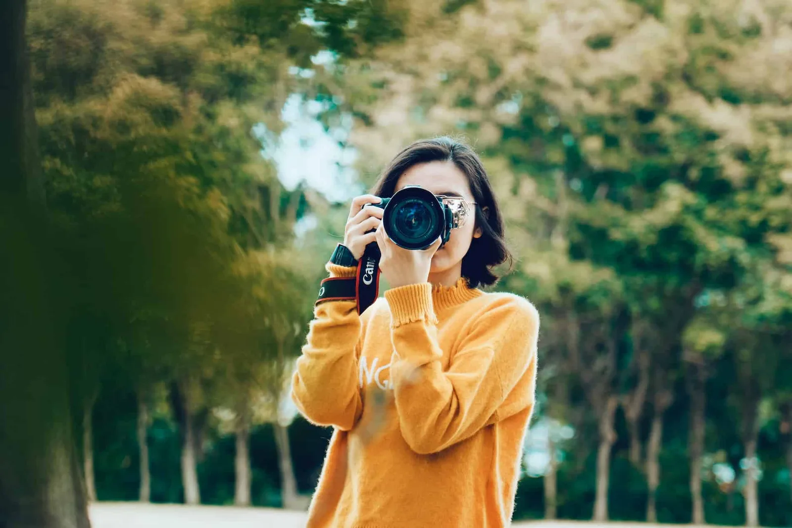 Photographe réalisant un portrait en lumière naturelle près d’une fenêtre, avec un fond doux et lumineux.