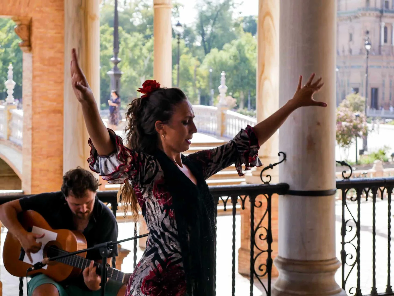 Danseuse en mouvement mêlant gestes de bras inspirés du flamenco et langage de danse contemporaine sur scène.