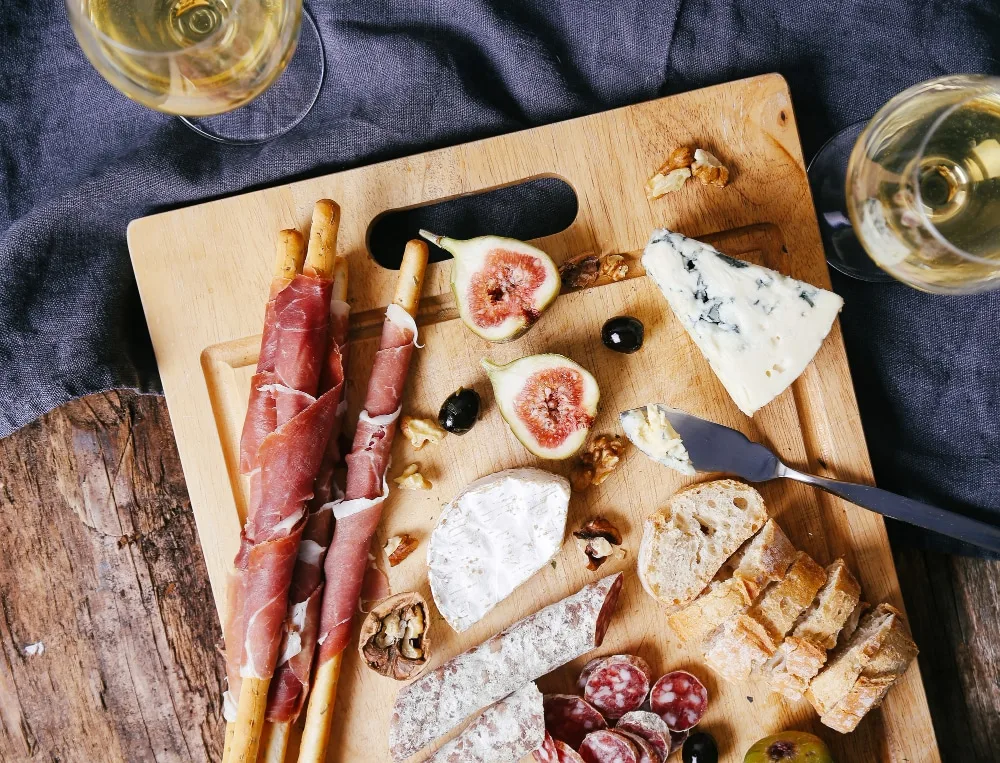 Plateau d’apéritif dînatoire avec mini-poivrons farcis, poivrons grillés et herbes fraîches.