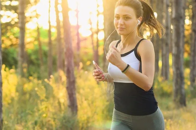 Femme portant une tenue de fitness confortable, composée d’une brassière et d’un legging, dans une salle lumineuse.