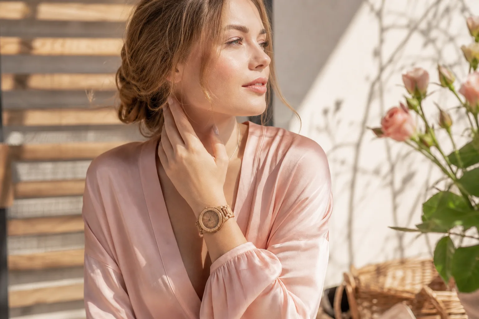 Montre en bois élégante pour femme, à cadran clair et bracelet à maillons en bois naturel, posée sur un tissu beige.