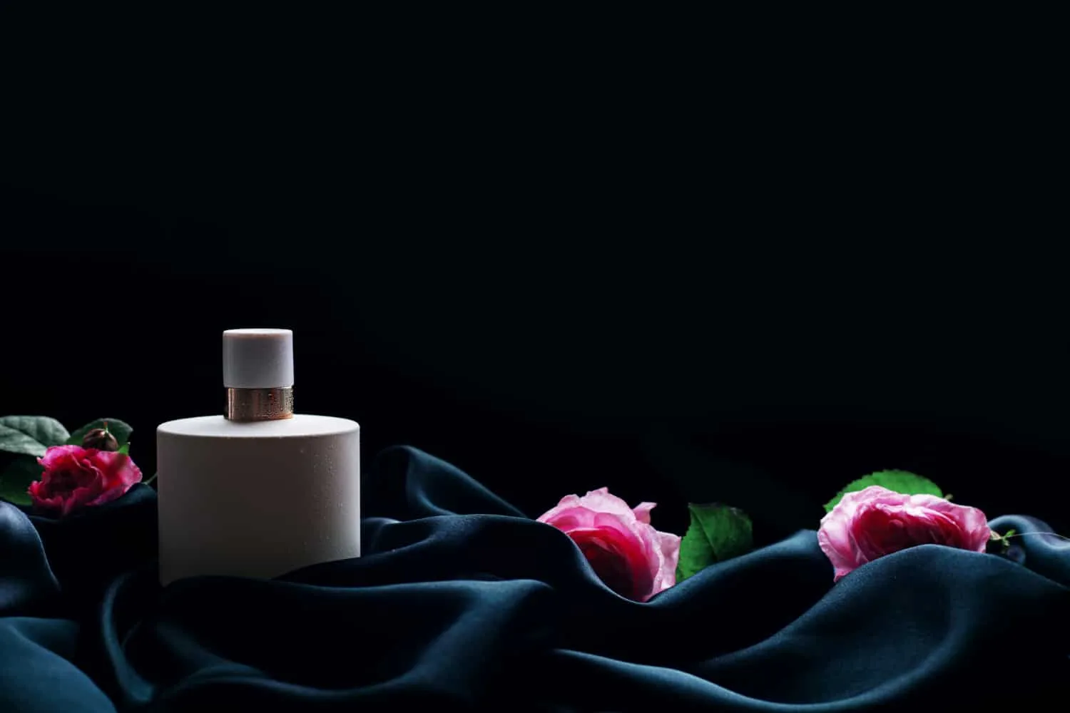 Alignement de flacons de parfum Narciso Rodriguez aux lignes minimalistes, dans des teintes blanc, noir et rose poudré.