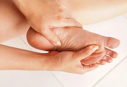 Femme réalisant une pédicure à domicile avec une râpe à pied sur le talon
