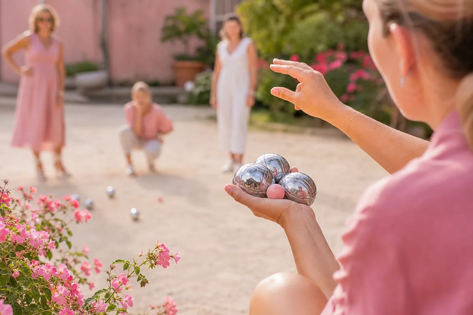 Deux joueuses de pétanque mesurent la distance entre le cochonnet et les boules sur un terrain de gravier.