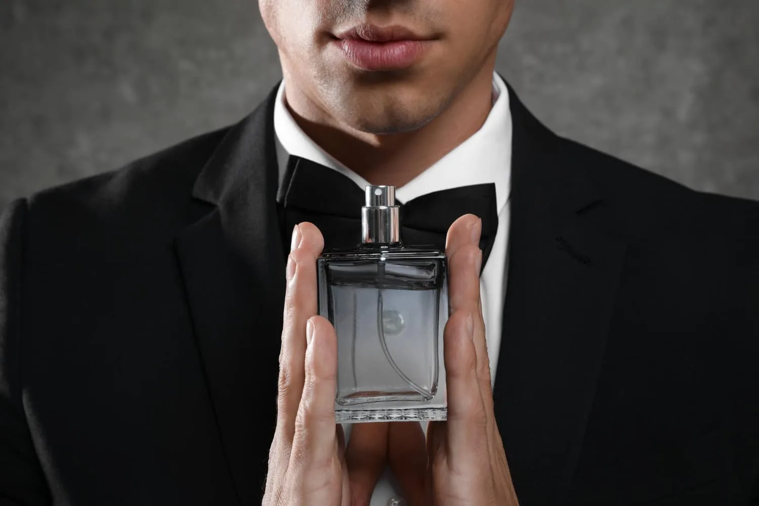 Homme élégant vaporisant un parfum boisé frais sur son poignet avant une sortie.