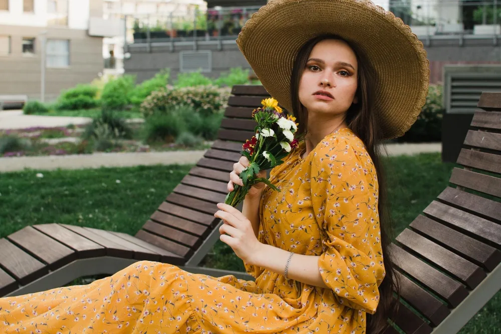 Femme portant une robe longue fluide avec veste légère et sandales, pour une tenue élégante du quotidien.