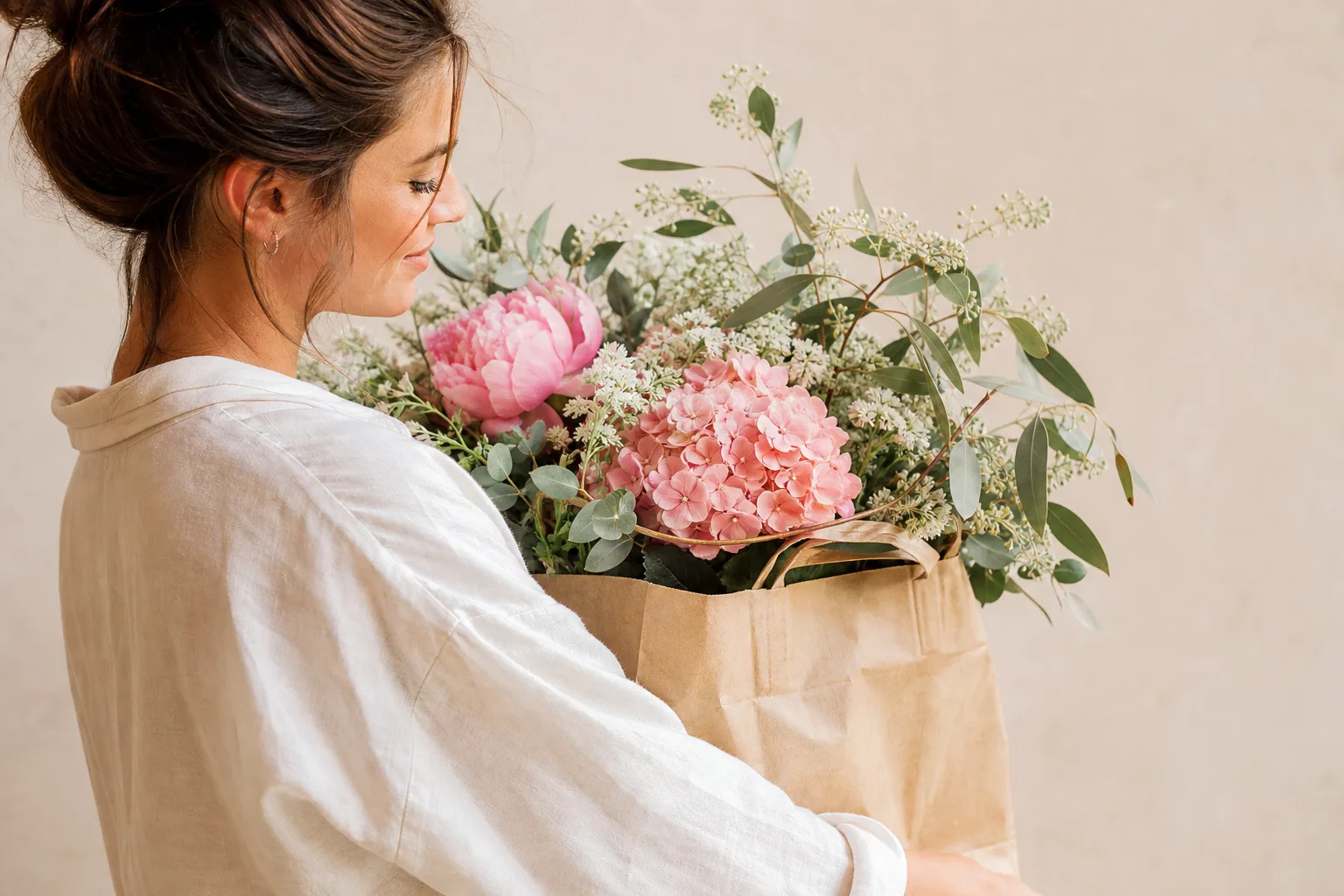 Sac kraft brun réutilisable posé sur une table avec des fruits, un bouquet et des emballages recyclables.