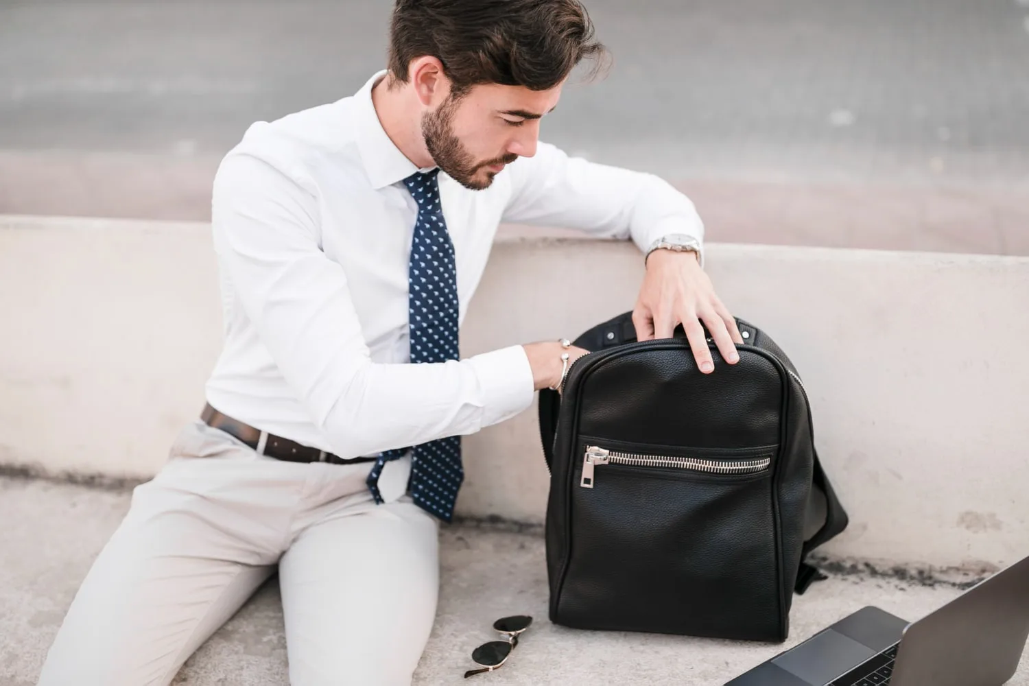 Homme portant une besace en bandoulière sobre avec rabat, adaptée au travail et aux déplacements quotidiens.