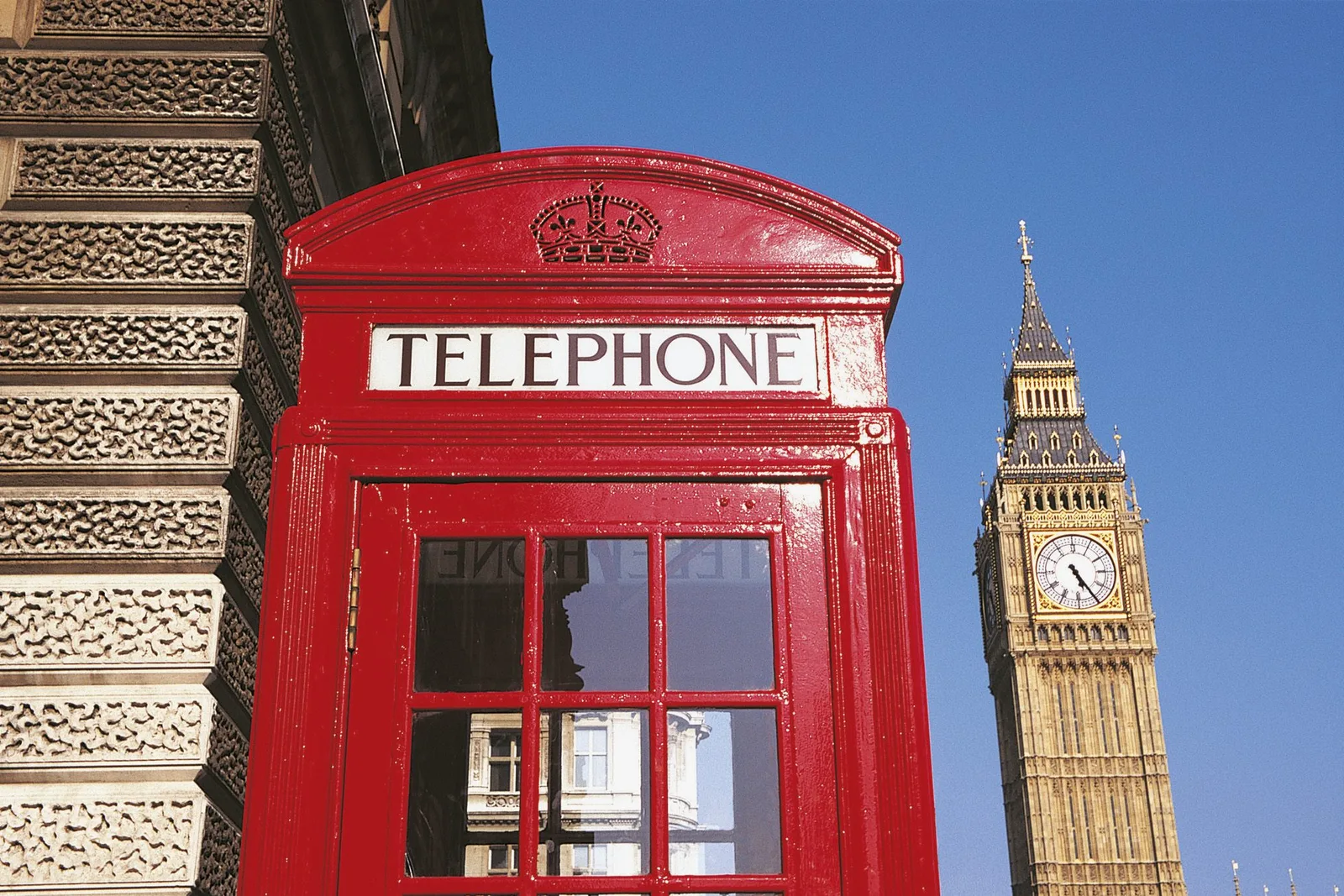 Jeune femme préparant son séjour linguistique en Angleterre avec une carte, un carnet et une tasse de thé.
